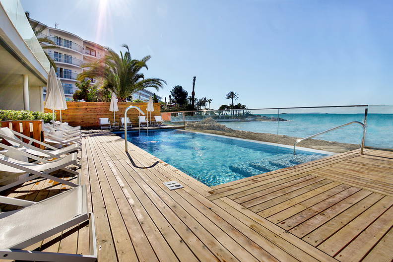 Basen z drewnianym tarasem z widokiem na morze.