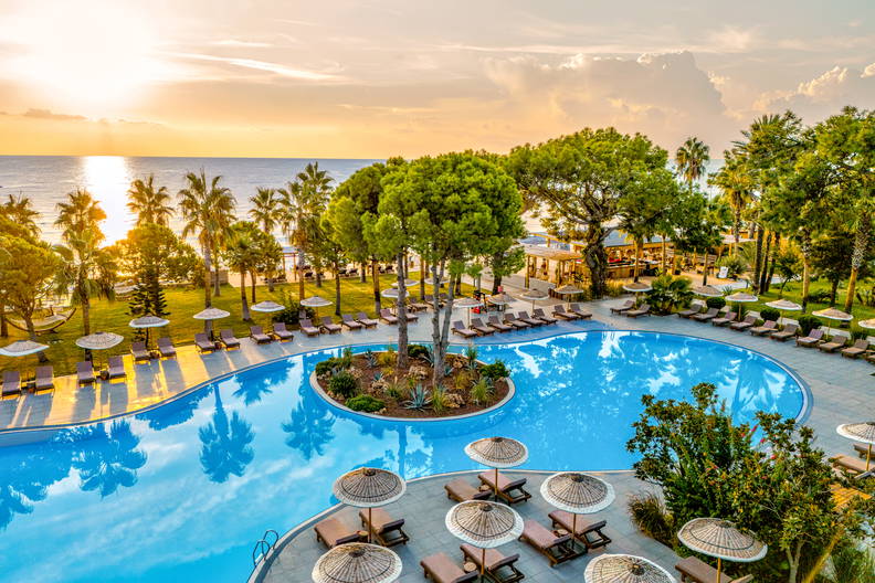 Basen w ośrodku wypoczynkowym z leżakami i parasolami, widok z góry.