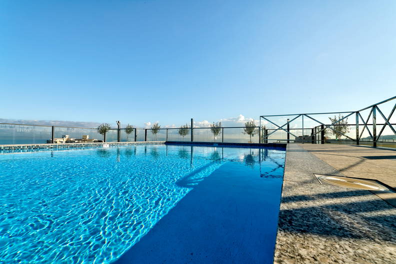 Basen z błękitną wodą na dachu budynku.