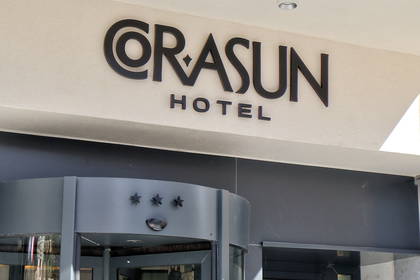 Wejście do hotelu Orasun z drzwiami obrotowymi i logo.