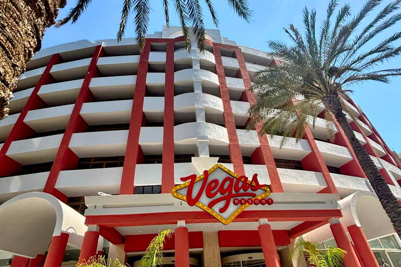 Budynek Vegas Resort z palmami na tle niebieskiego nieba.