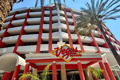 Budynek Vegas Resort z palmami na tle niebieskiego nieba.
