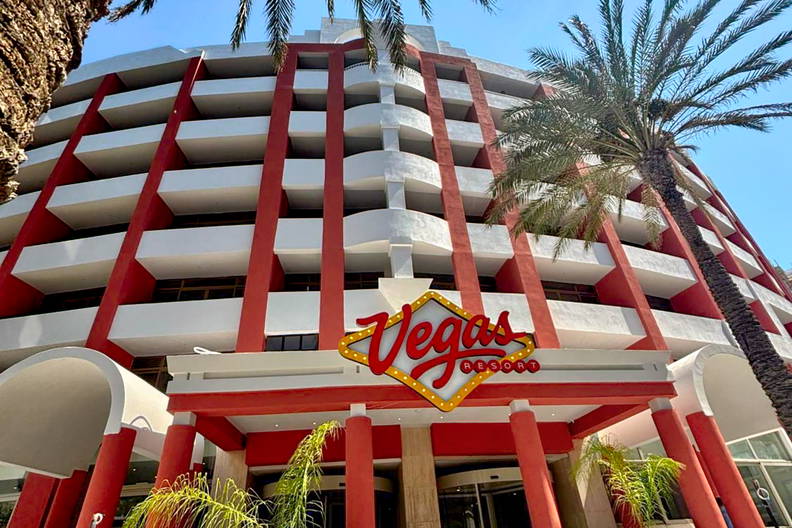 Budynek Vegas Resort z palmami na tle niebieskiego nieba.