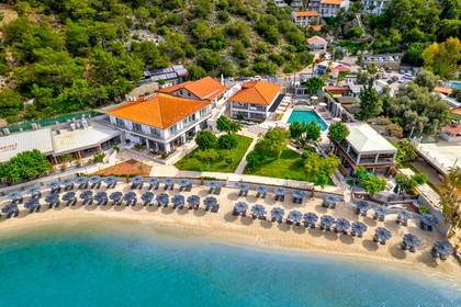 Hotel przy plaży z basenem i parasolami, widok z góry.
