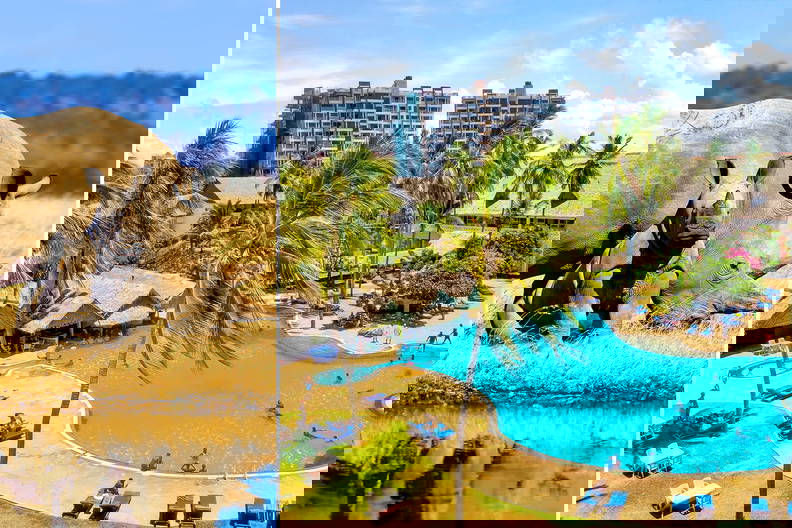 Nosorożec z młodym przechadza się obok basenu hotelowego.