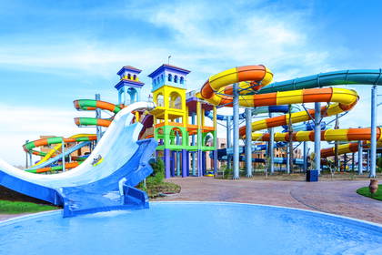 Kolorowy aquapark z wieloma krętymi zjeżdżalniami i basenem.