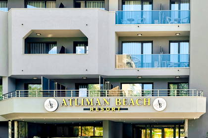 Nowoczesna, szara fasada hotelu Atliman Beach Resort z licznymi balkonami.