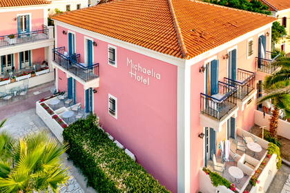 Widok z góry na różowy hotel Michaelia z pomarańczowym dachem i niebieskimi okiennicami.