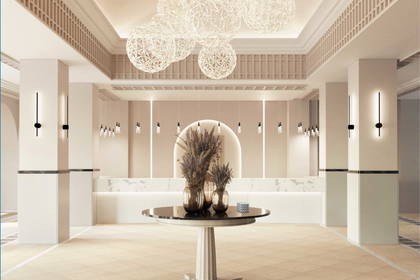 Eleganckie lobby hotelowe z okrągłym stołem, ladą recepcyjną i kulistymi żyrandolami.