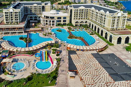 Widok z lotu ptaka na duży, nadmorski kompleks hotelowy z parkiem wodnym.