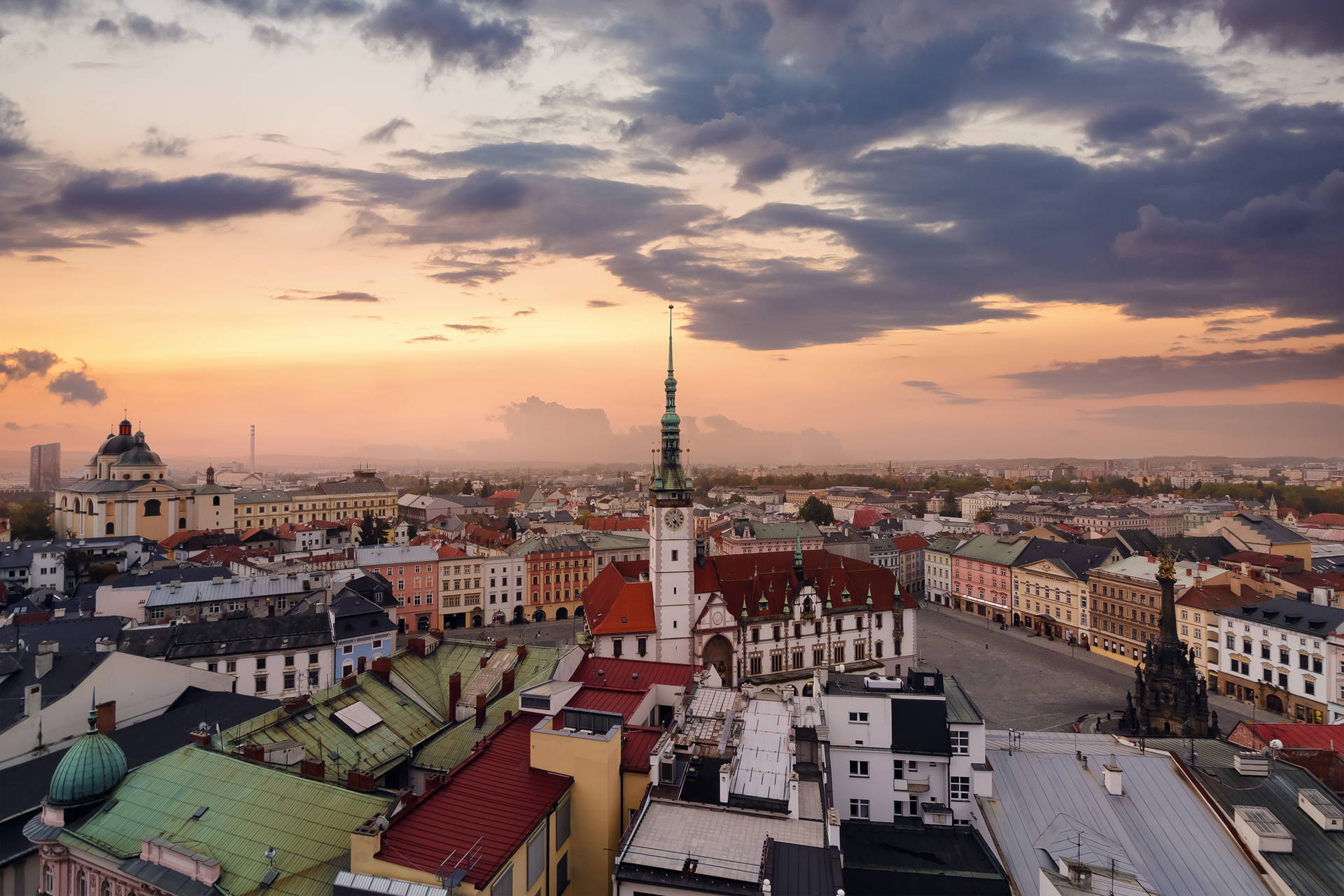 Panorama miasta Ołomuniec z wieżą ratuszową na tle kolorowego, zmierzchowego nieba.