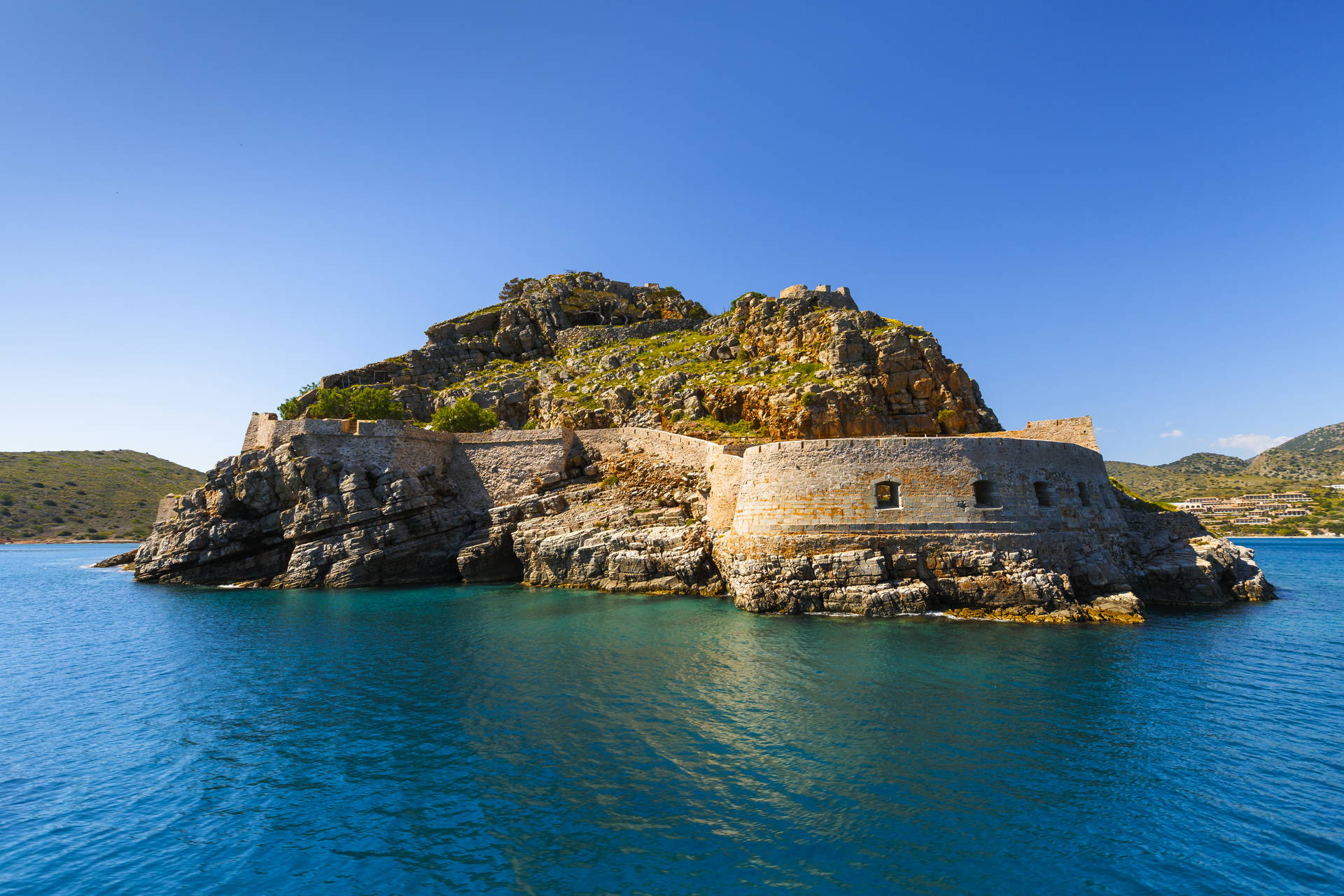 Spinalonga – forteca na skalistej wyspie otoczona lazurową wodą.