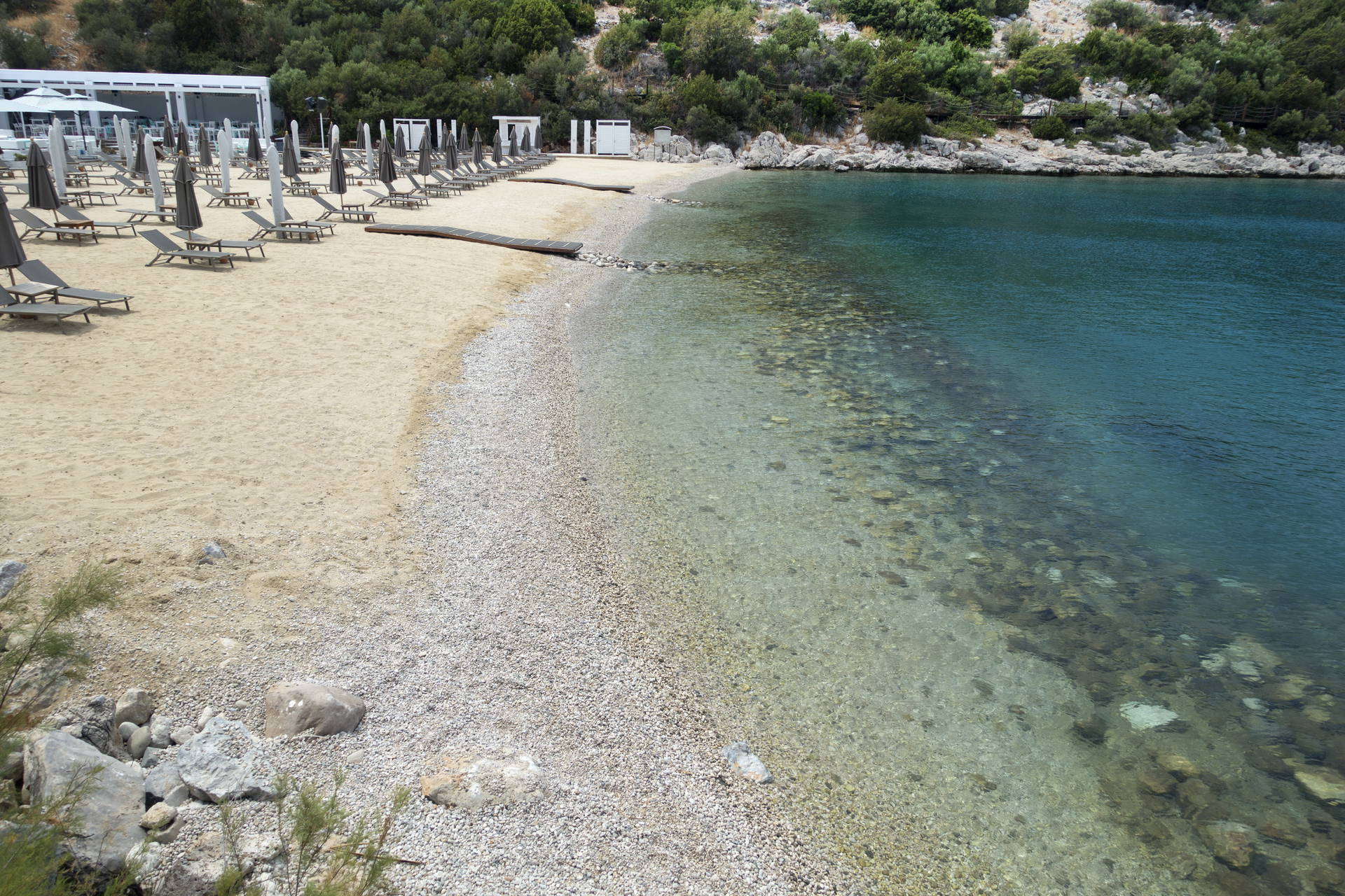 Plaża z leżakami i parasolami.