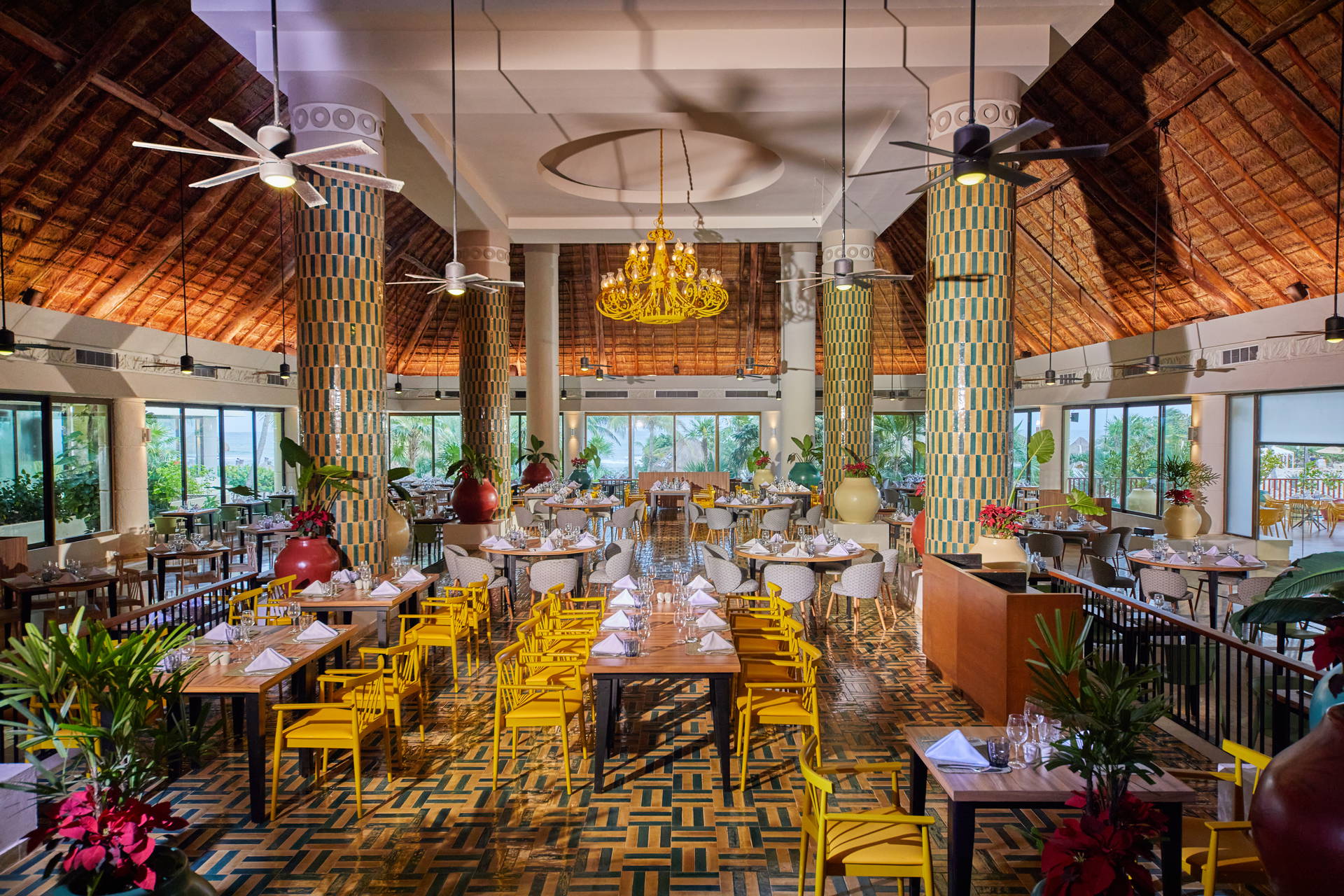 Restauracja z żółtymi krzesłami i nakrytymi stołami.