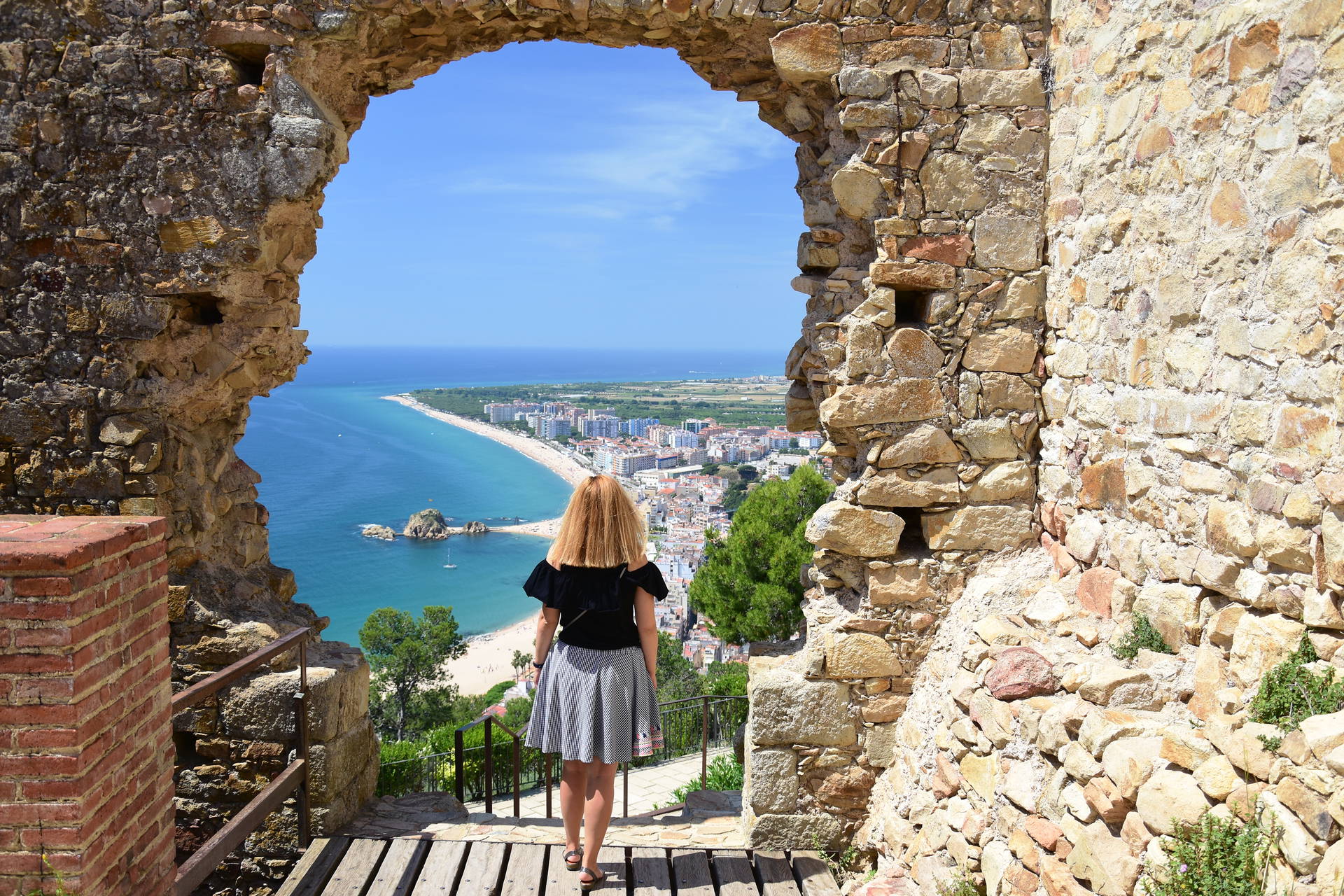 Kobieta patrzy na wybrzeże z ruin zamku w Tossa de Mar.