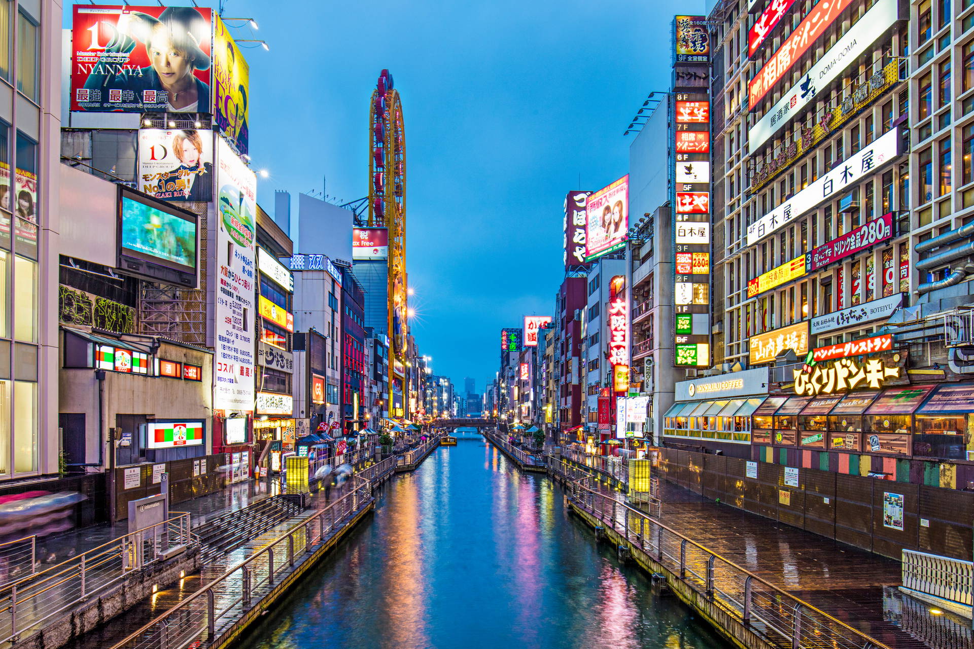 Ulica Dotonbori w Osace nocą. Neony odbijają się w rzece.
