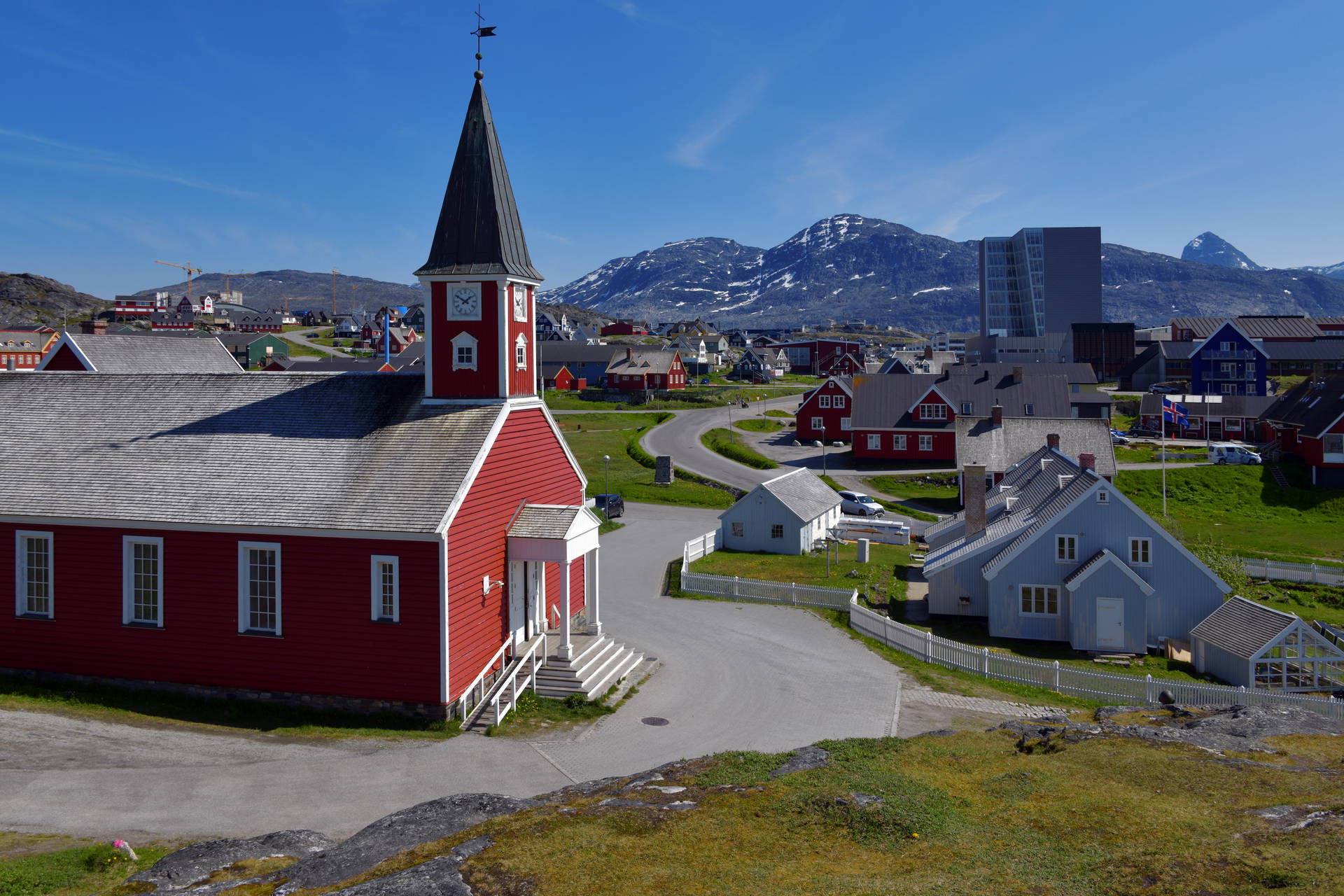 Kościół Zbawiciela w Nuuk z 1849 roku na tle panoramy miasta i gór.