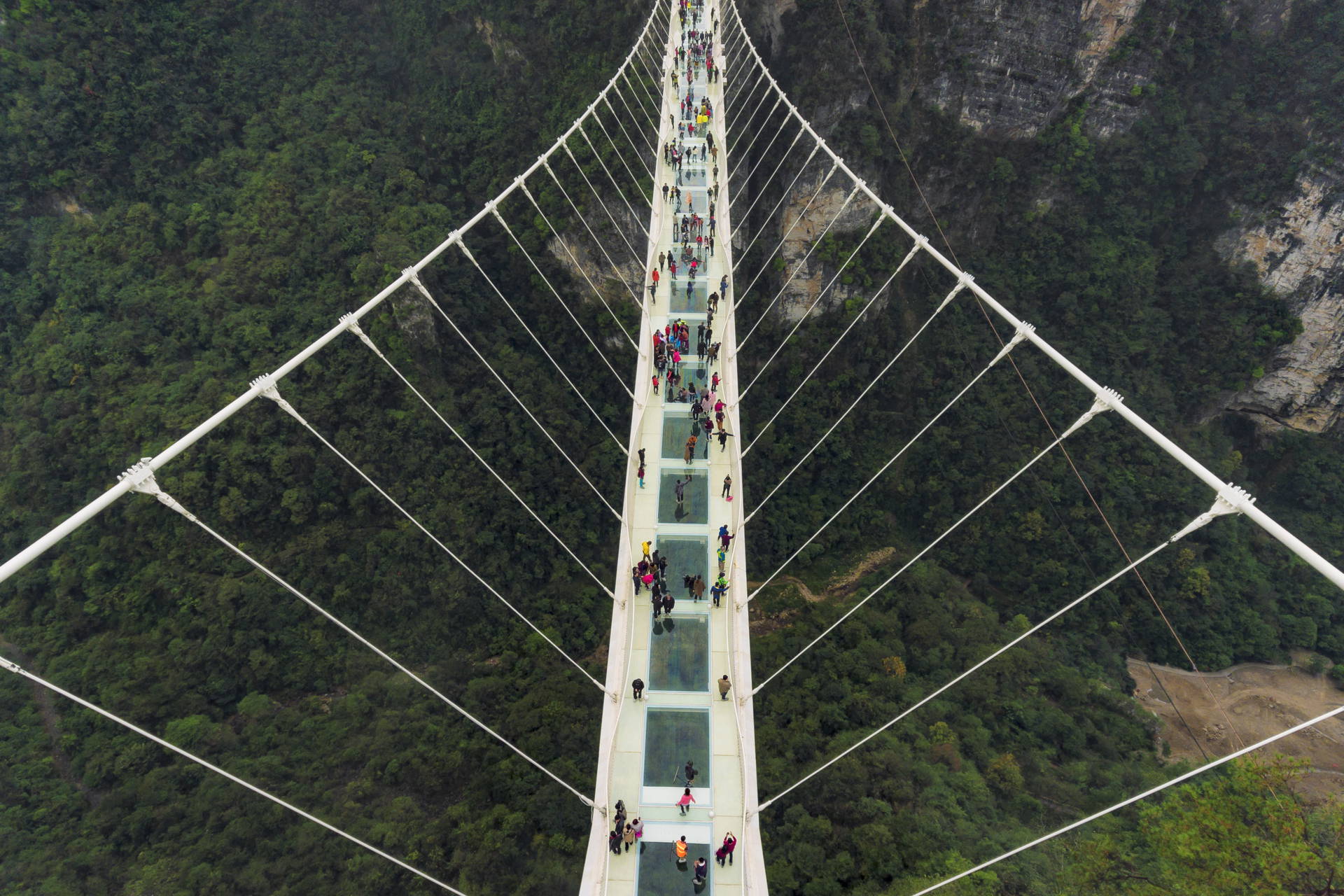 Szklany most w Zhangjiajie, Chiny, z turystami.