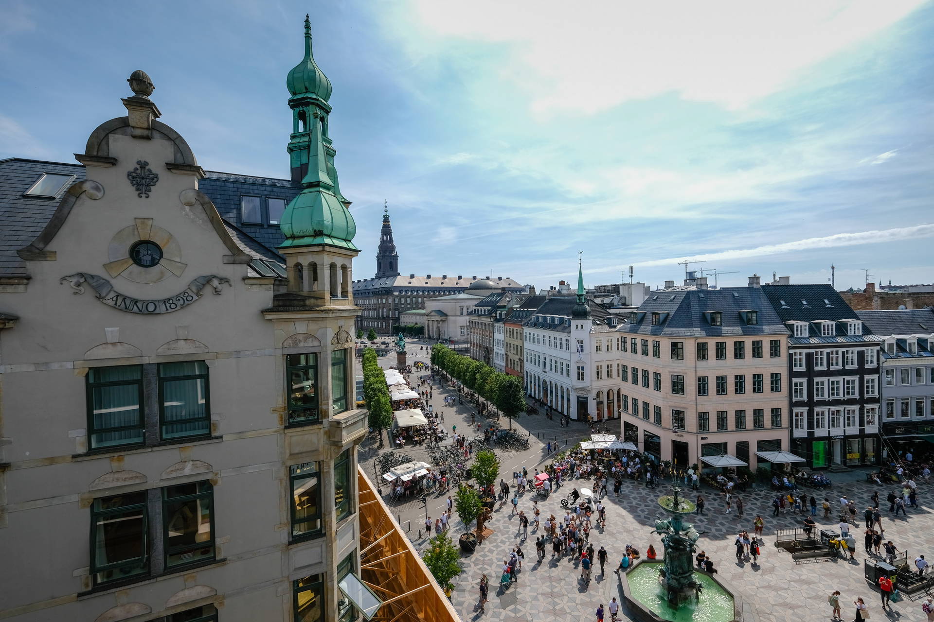 Plac Højbro w Kopenhadze z fontanną i zabudową miejską.