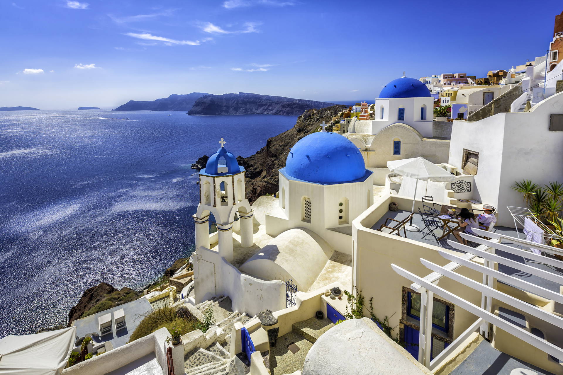 Białe budynki z niebieskimi kopułami w Santorini w Grecji.
