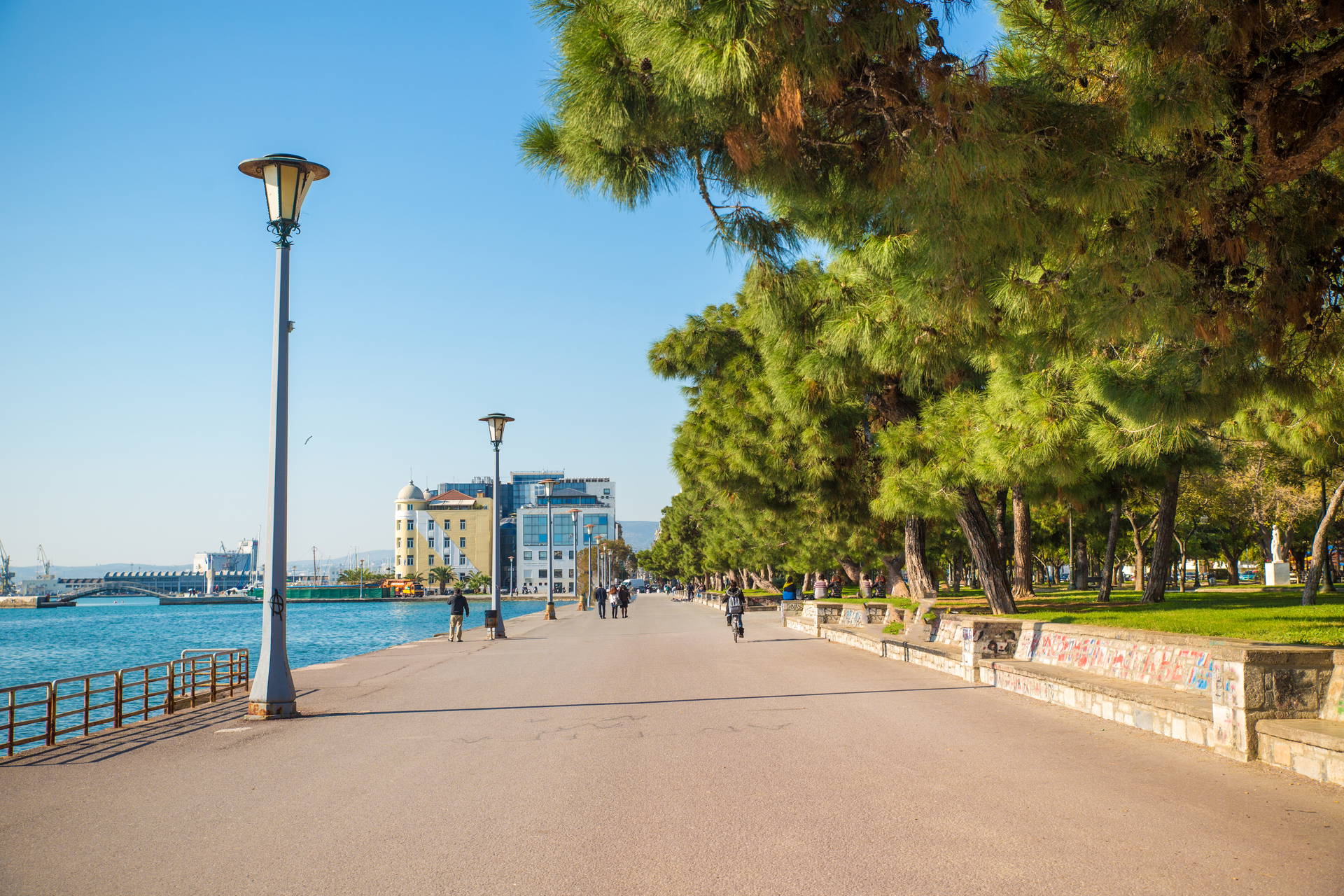 Promenada nadmorska w Salonikach z latarniami i drzewami.