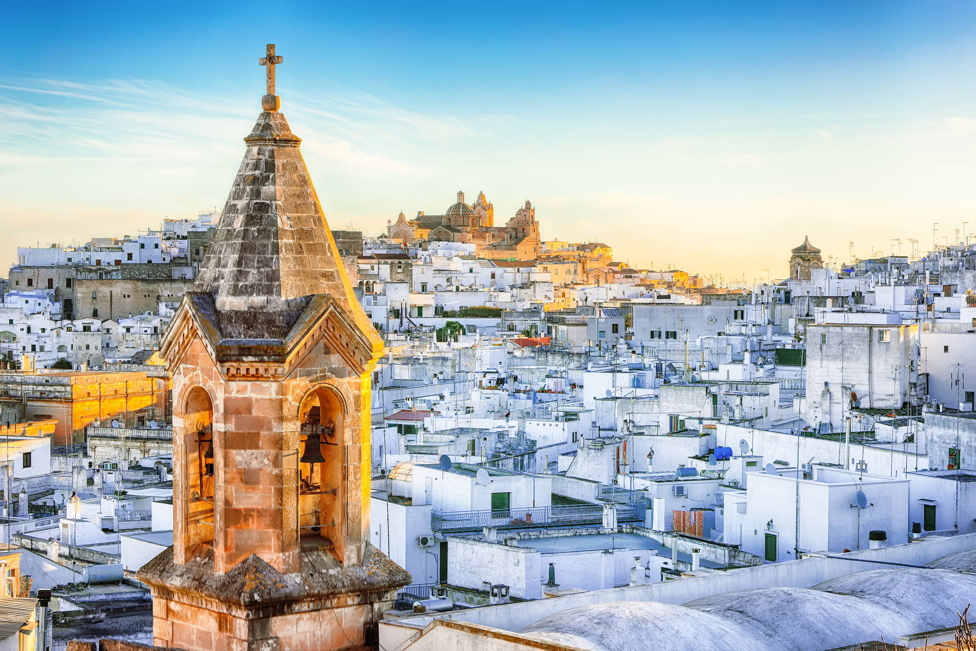 Widok na Ostuni z kamienną wieżą kościoła na pierwszym planie.
