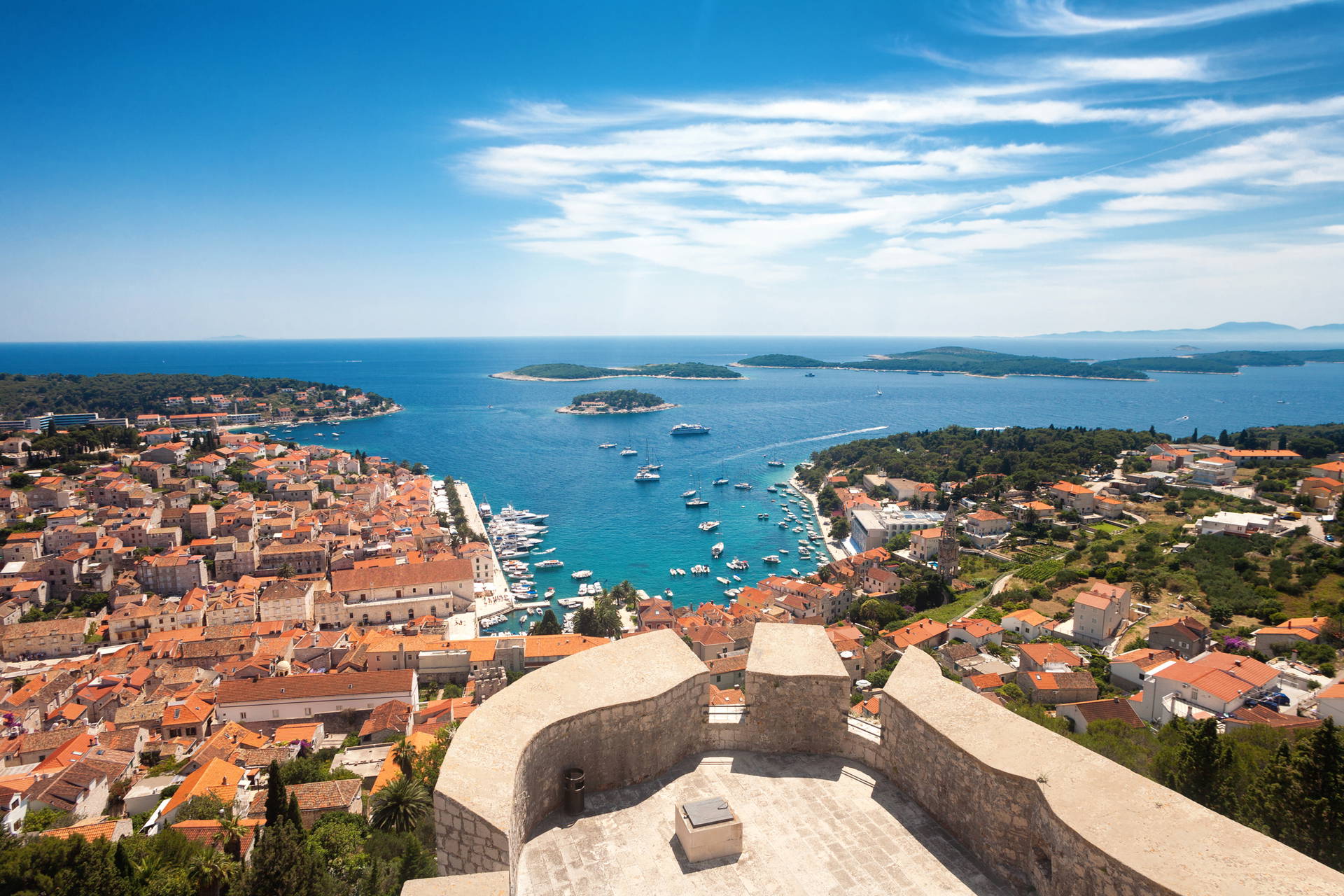 Widok z góry na miasto Hvar w Chorwacji. Widać czerwone dachy budynków i morze.