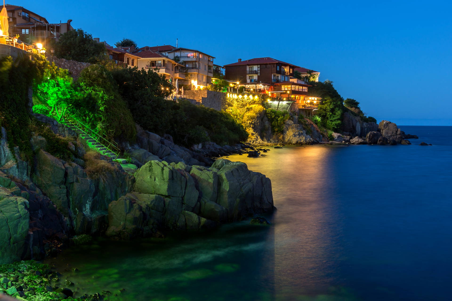 Nocny widok na Sozopol: budynki na klifie nad morzem.