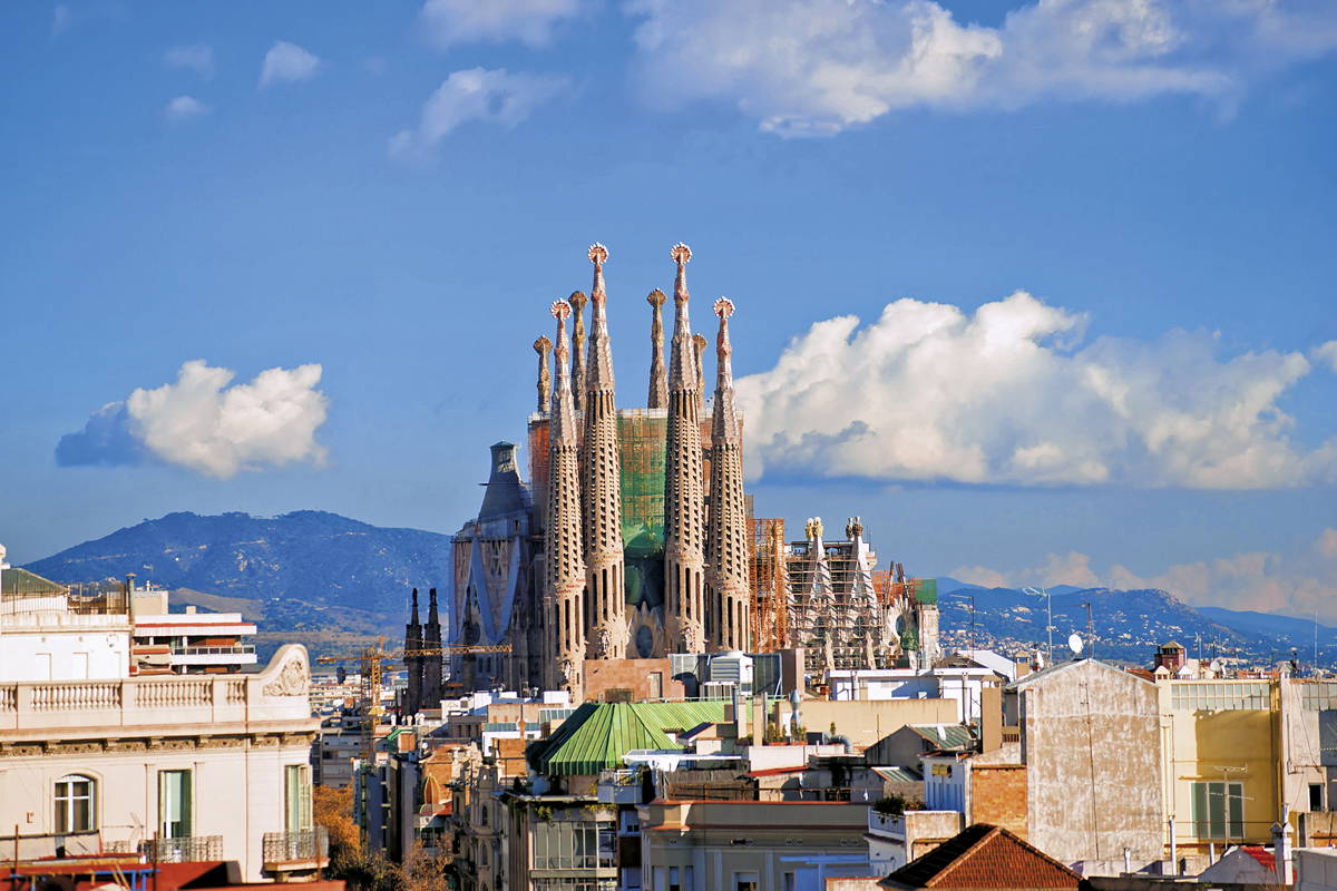 Panorama Barcelony z Sagradą Familią na tle błękitnego nieba.