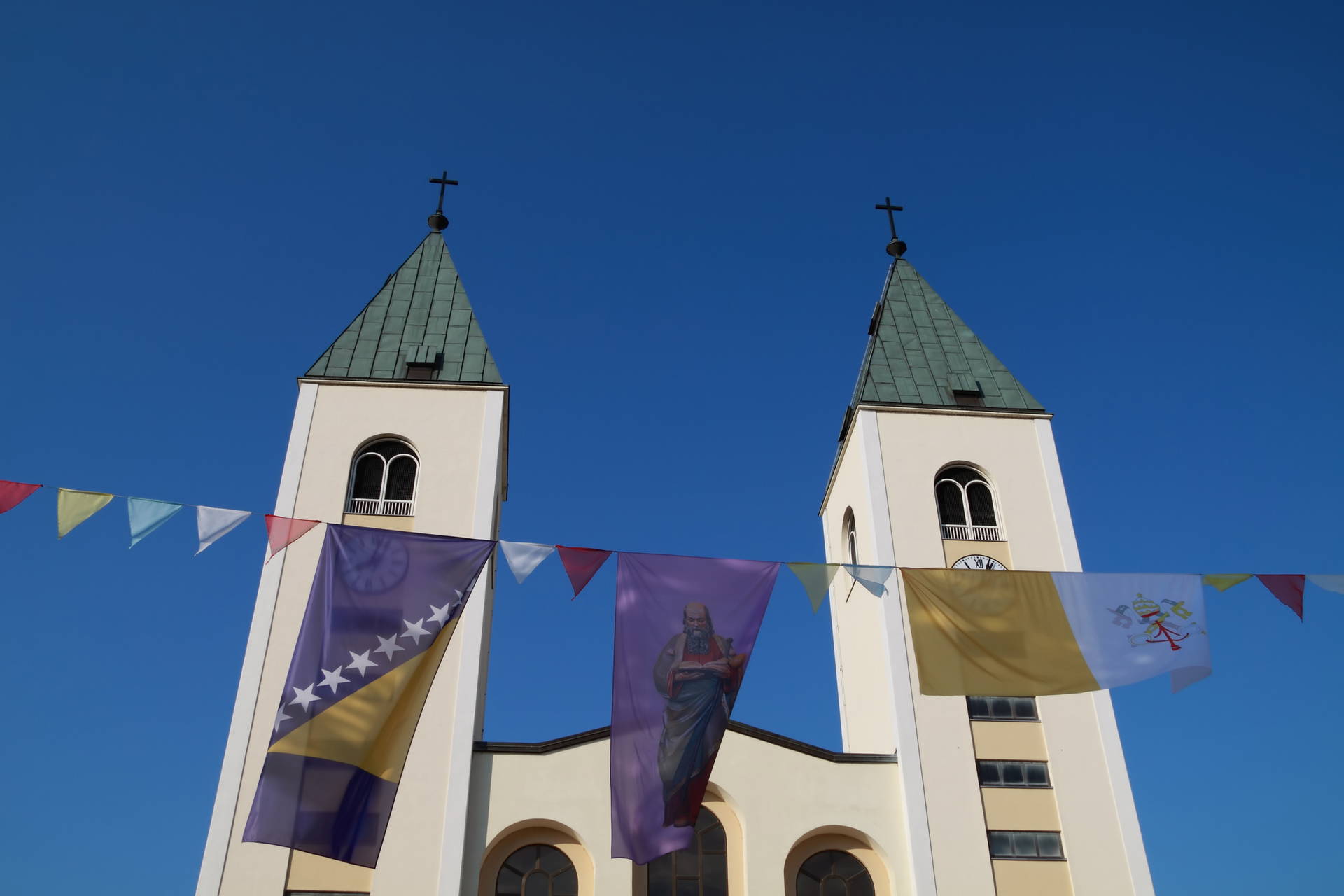 Fasada kościoła św. Jakuba w Medziugorie udekorowana flagami.