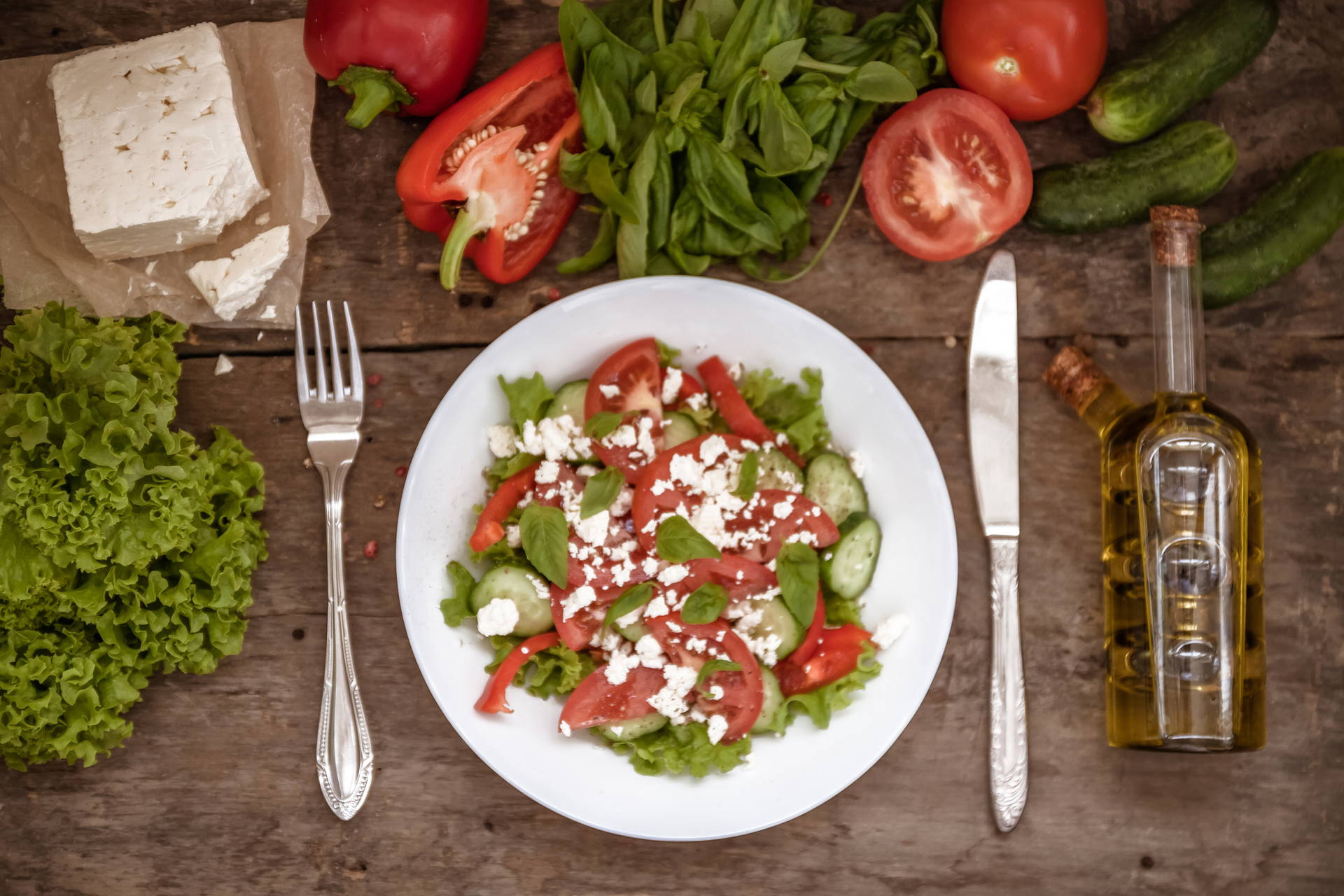 Sałatka grecka z serem feta, pomidorami i ogórkiem na stole.