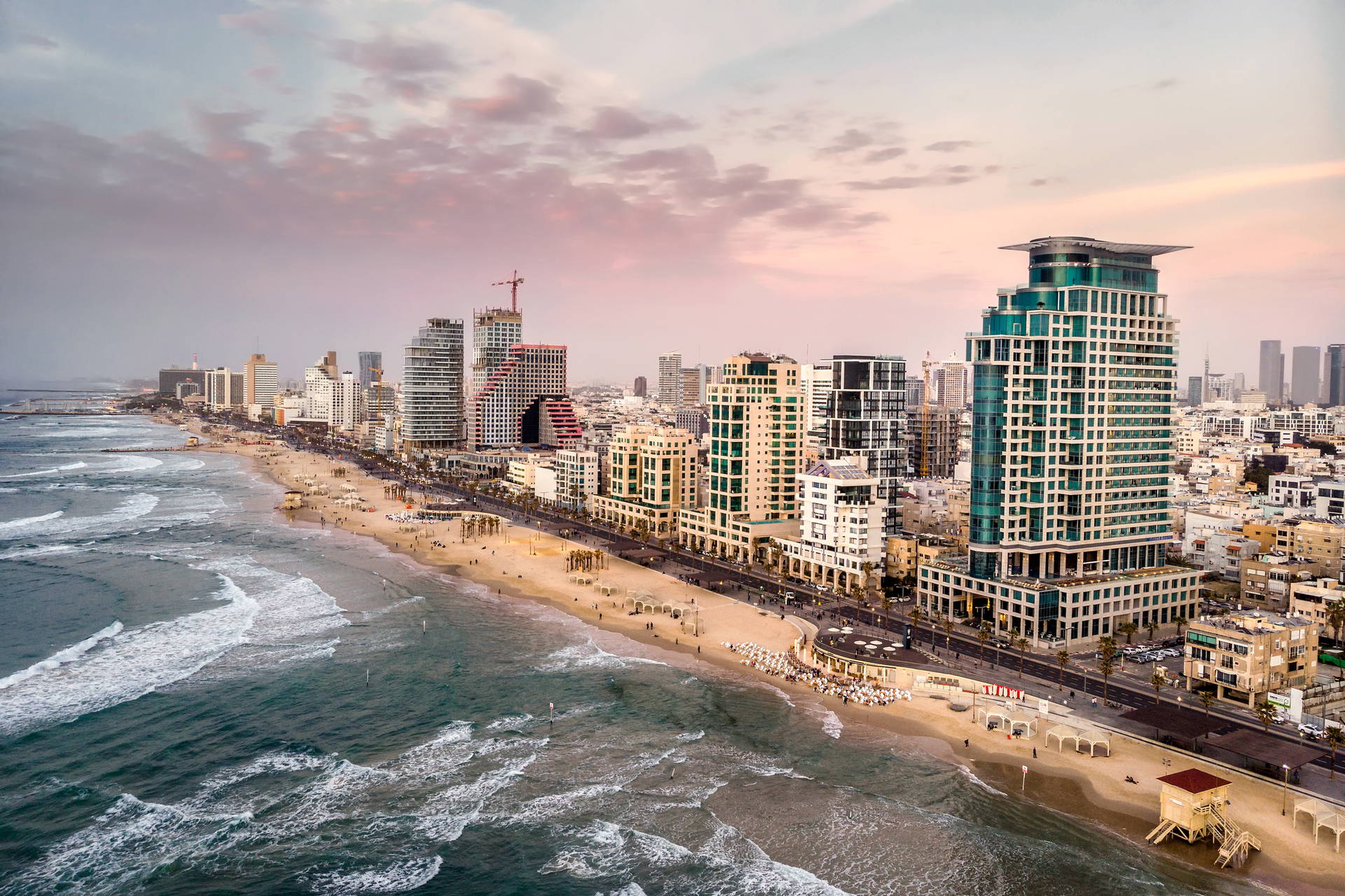 Panorama Tel Awiwu z plażą, morzem i budynkami.