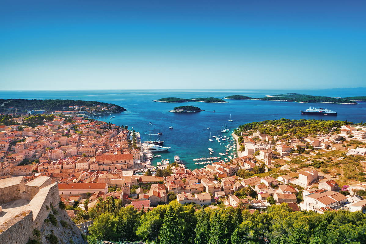 Panorama miasta Hvar w Chorwacji z widokiem na morze, wyspy i łodzie.
