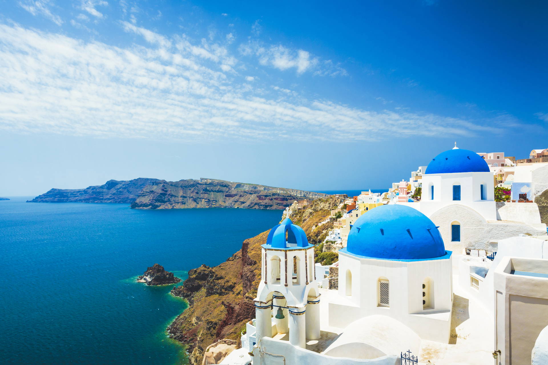 Białe budynki z niebieskimi kopułami na Santorini.