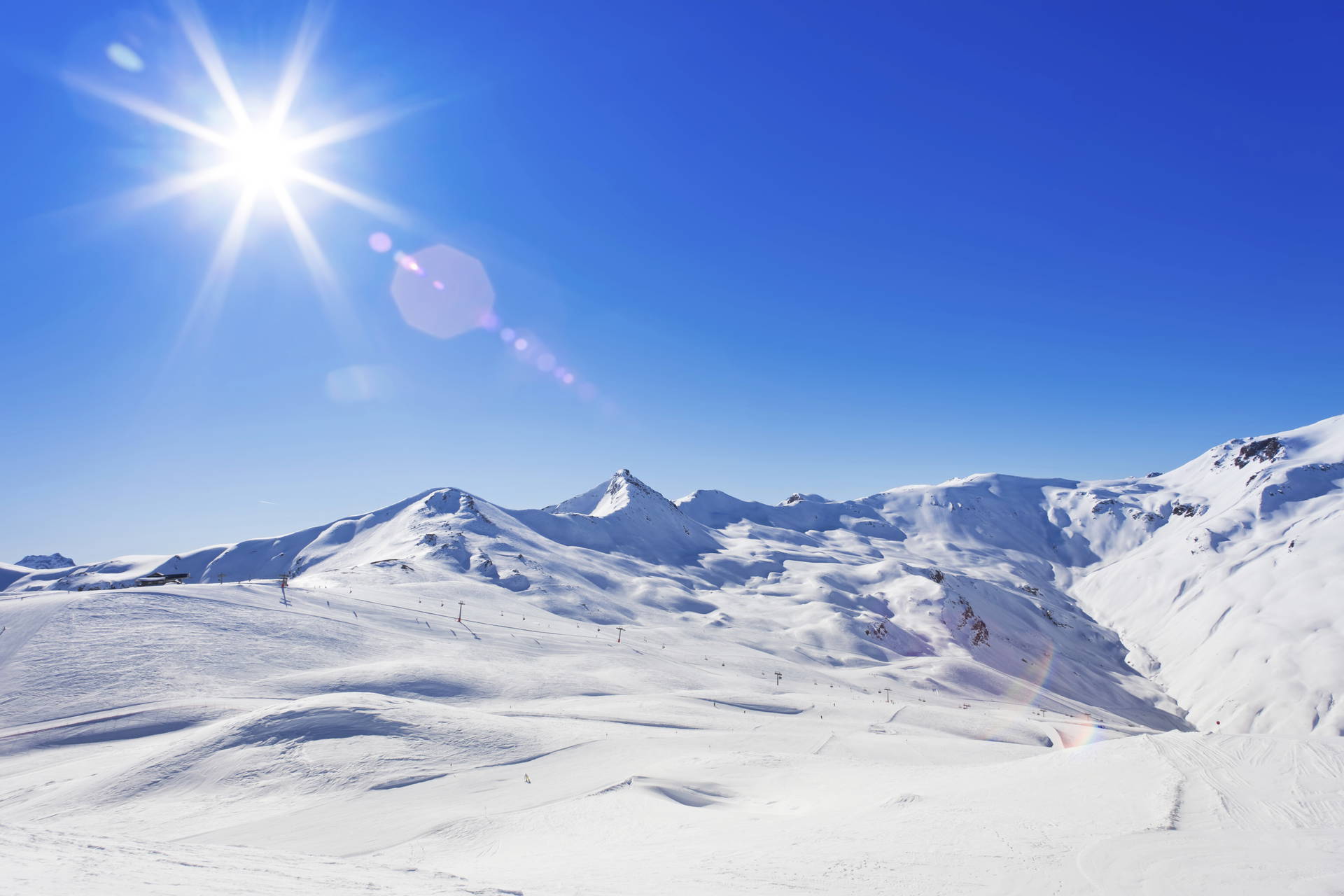 Krajobraz górski pokryty śniegiem w słoneczny dzień.