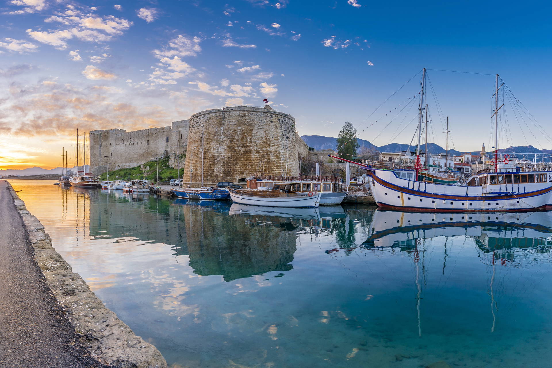 Panorama portu w Kyrenii z zamkiem i jachtami.