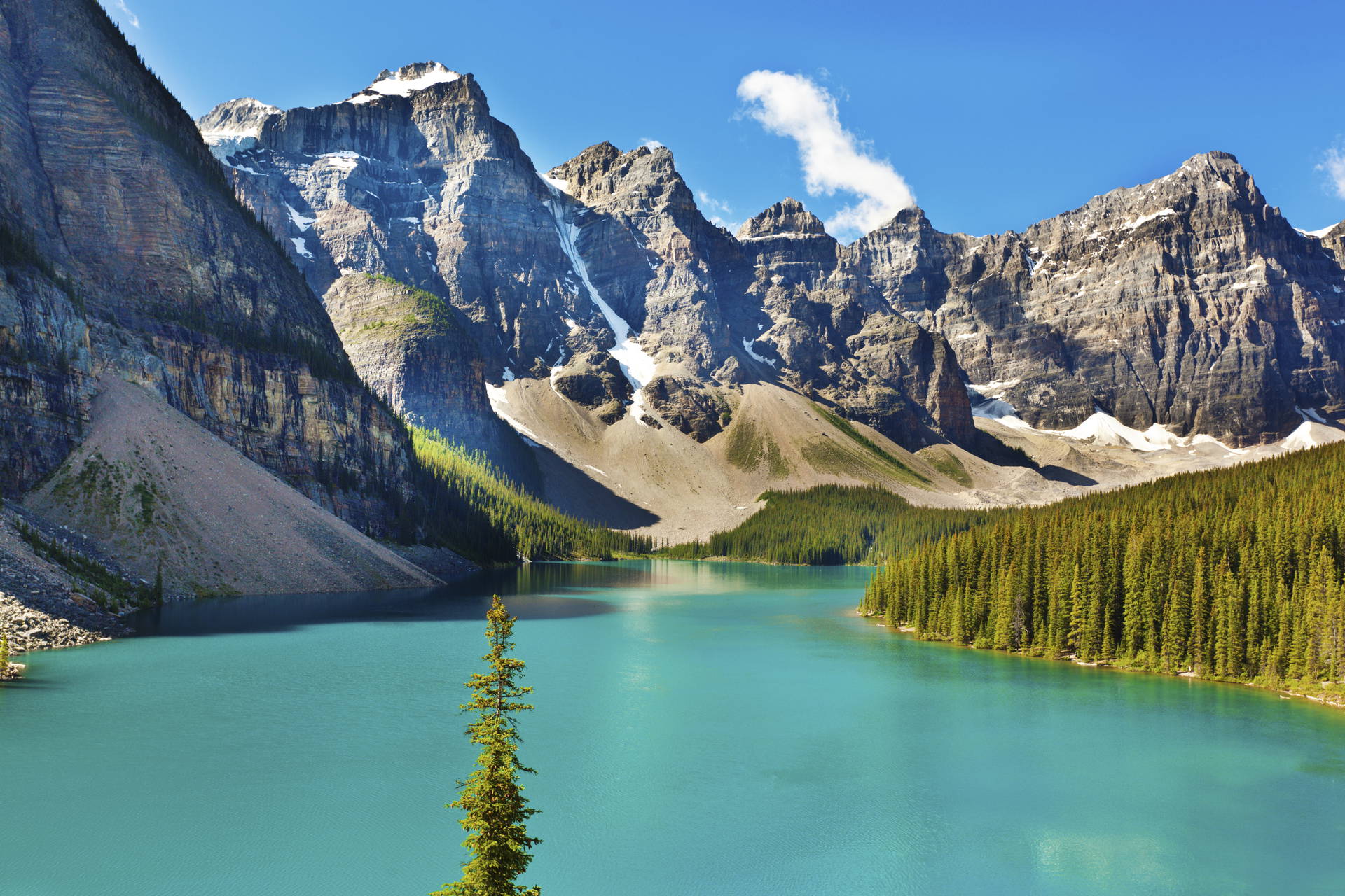 Turkusowe jezioro Moraine otoczone górami i lasem.