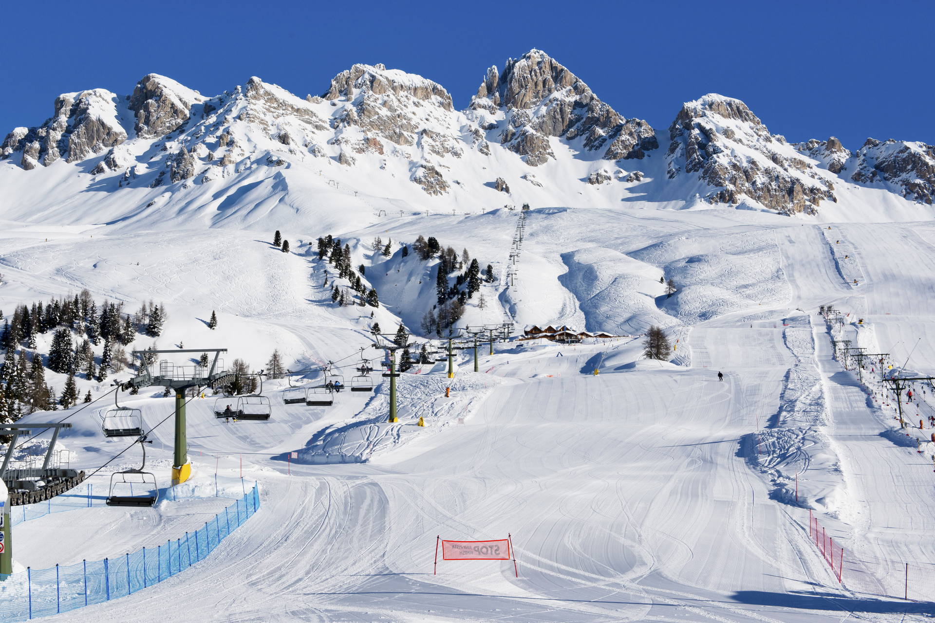 Słoneczny krajobraz górski ze stokiem narciarskim.