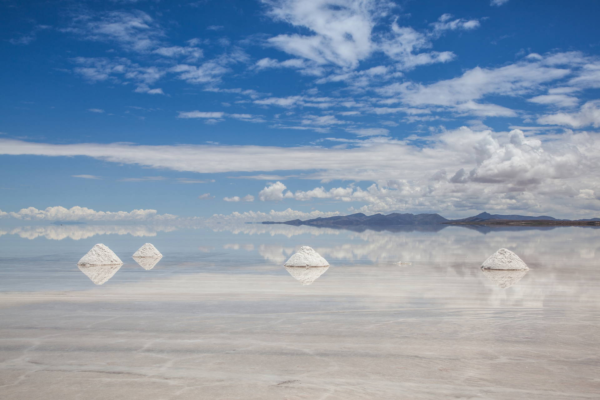 Salar de Uyuni, Boliwia: solnisko z hałdami soli odbijające niebo.