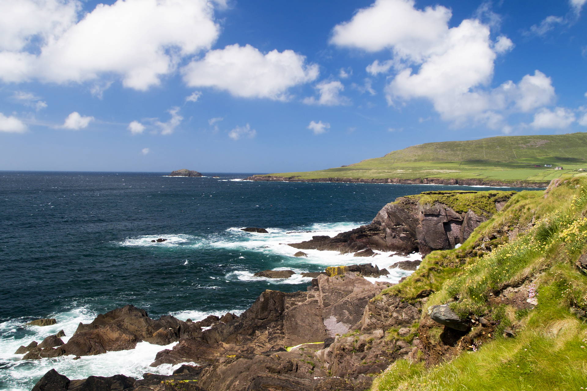 Irlandzkie wybrzeże z klifami i zielenią.