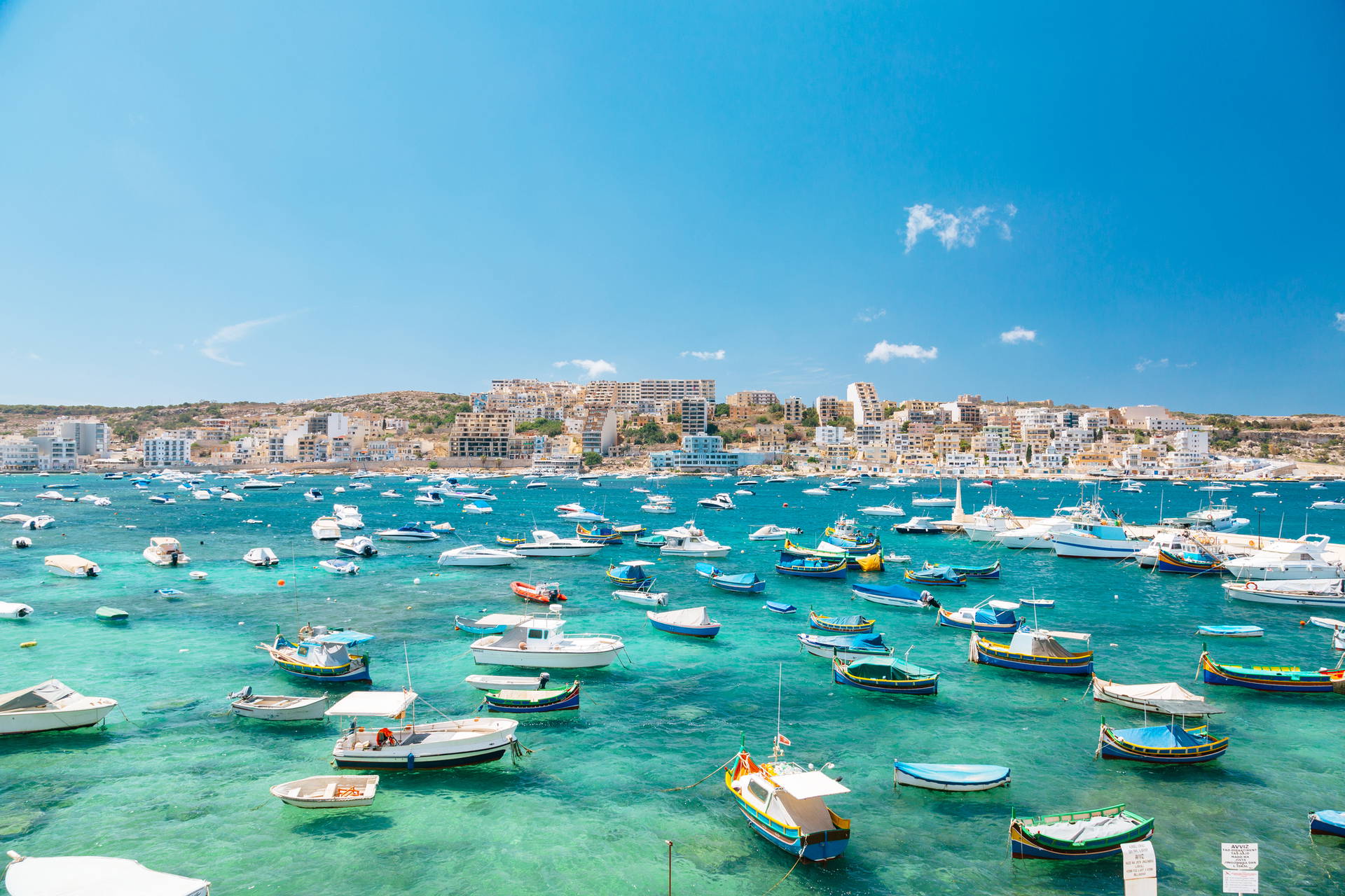 Marsaxlokk na Malcie: widok na zatokę z kolorowymi łodziami.