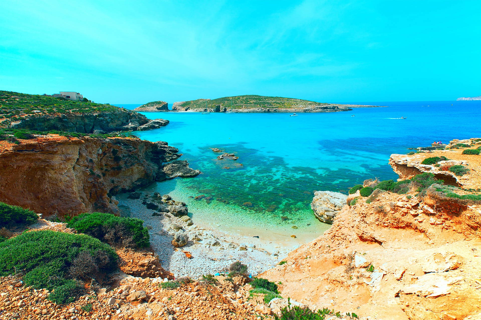 Malta, Blue Lagoon: turkusowa zatoka otoczona skałami i roślinnością.