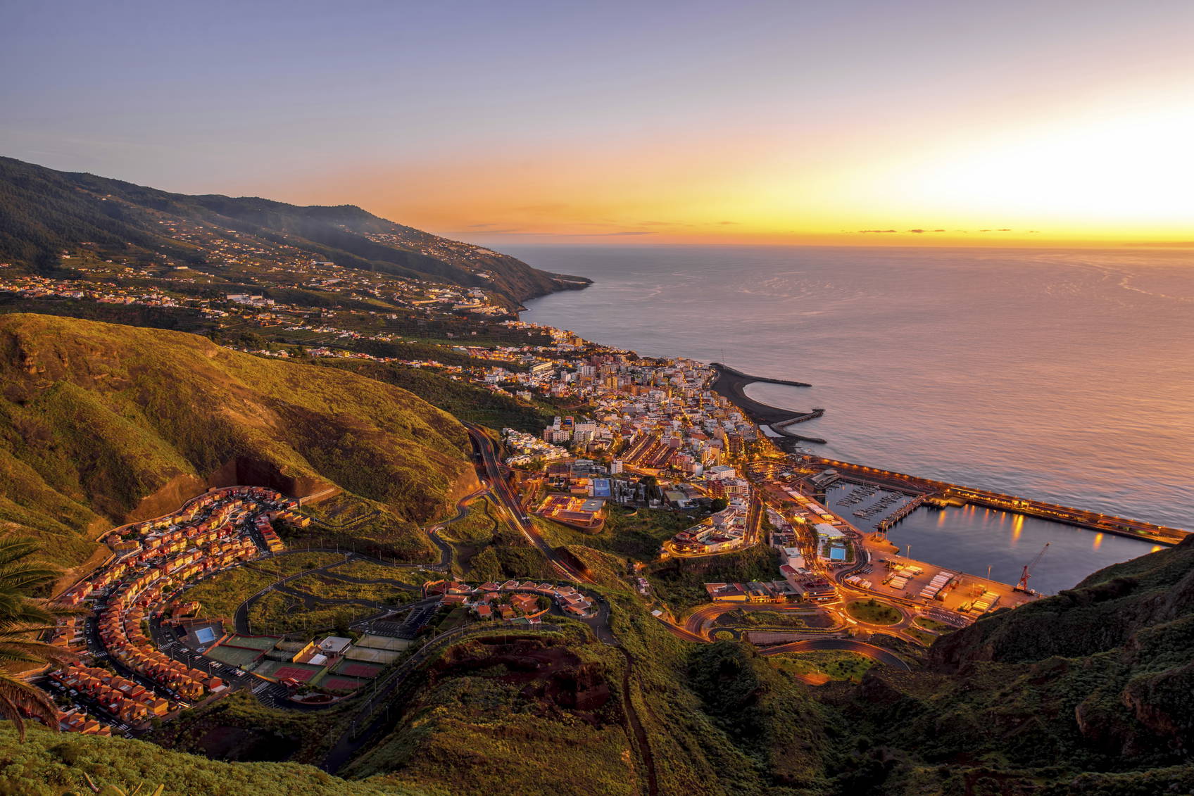 Panorama miasta nad oceanem o zmierzchu.