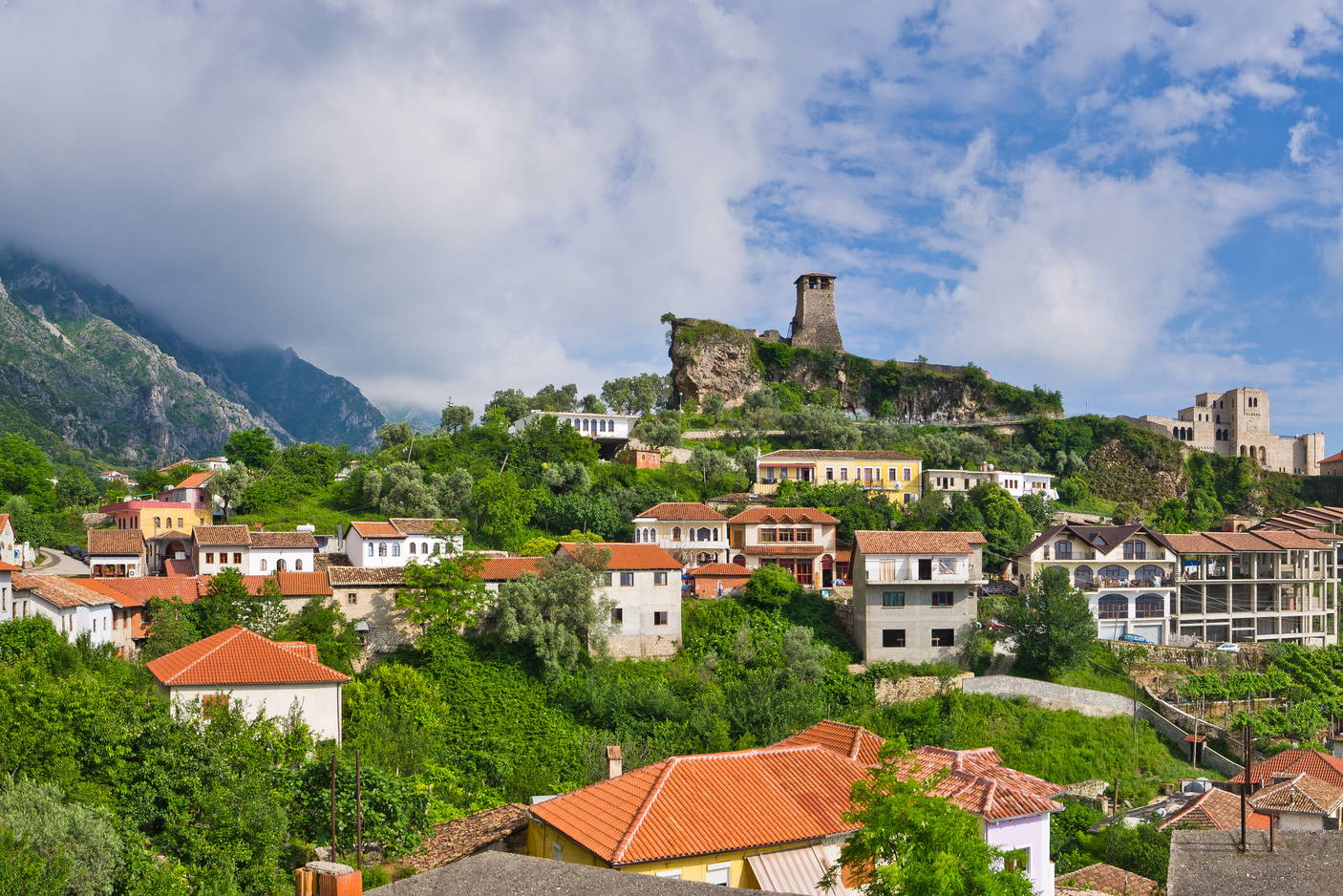 Panorama albańskiego miasta Kruja z widokiem na góry i błękitne niebo.