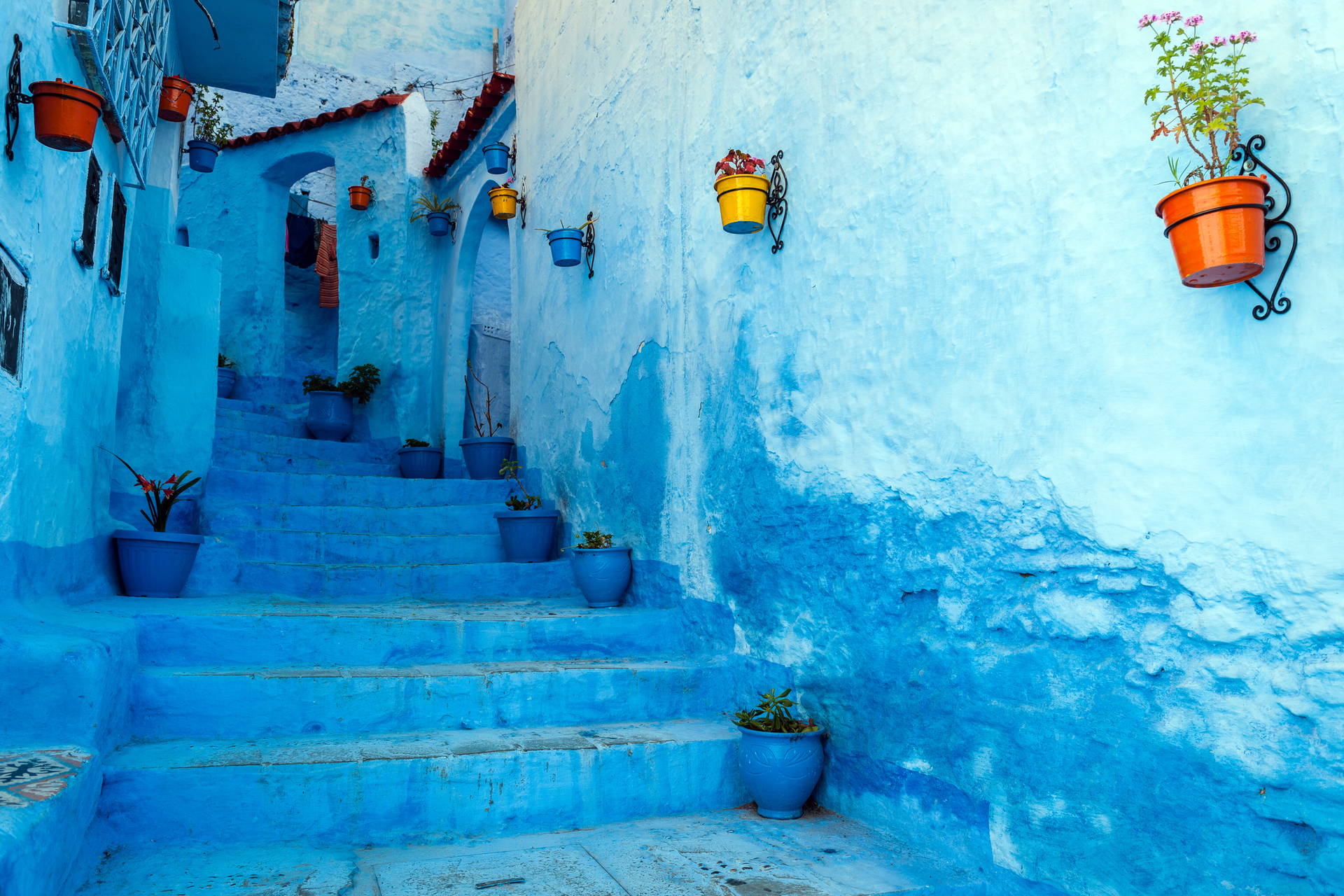Ulica w Chefchaouen z niebieskimi ścianami i schodami.