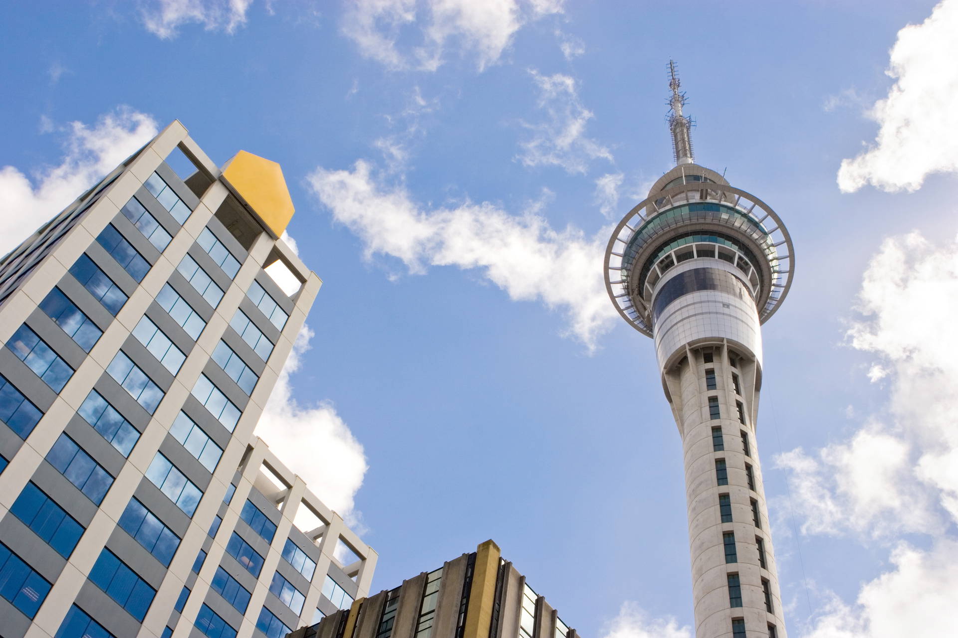 Sky Tower w Auckland na tle zabudowy miejskiej i nieba.