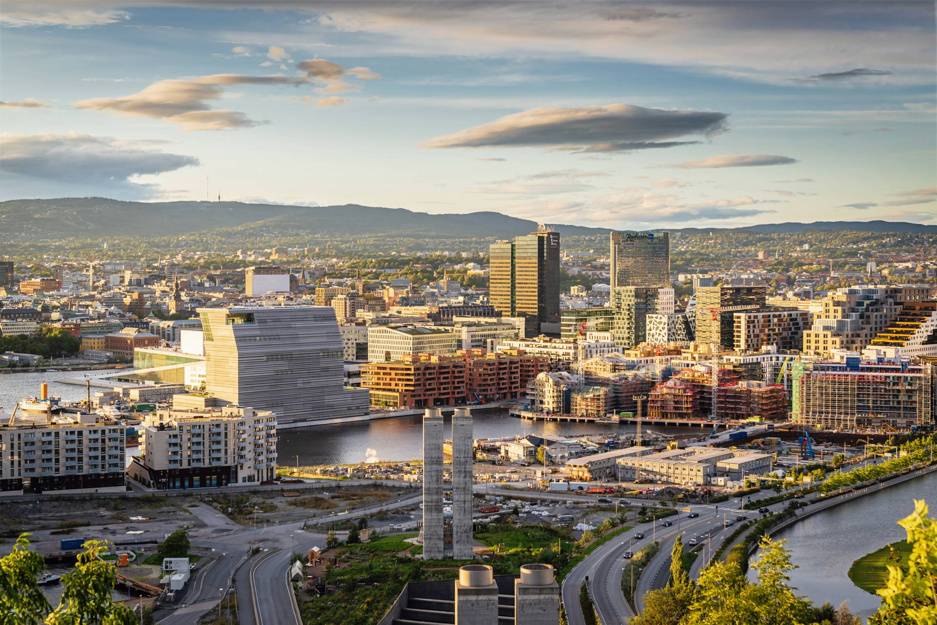 Panorama Oslo z budynkami i wzgórzami na tle nieba.