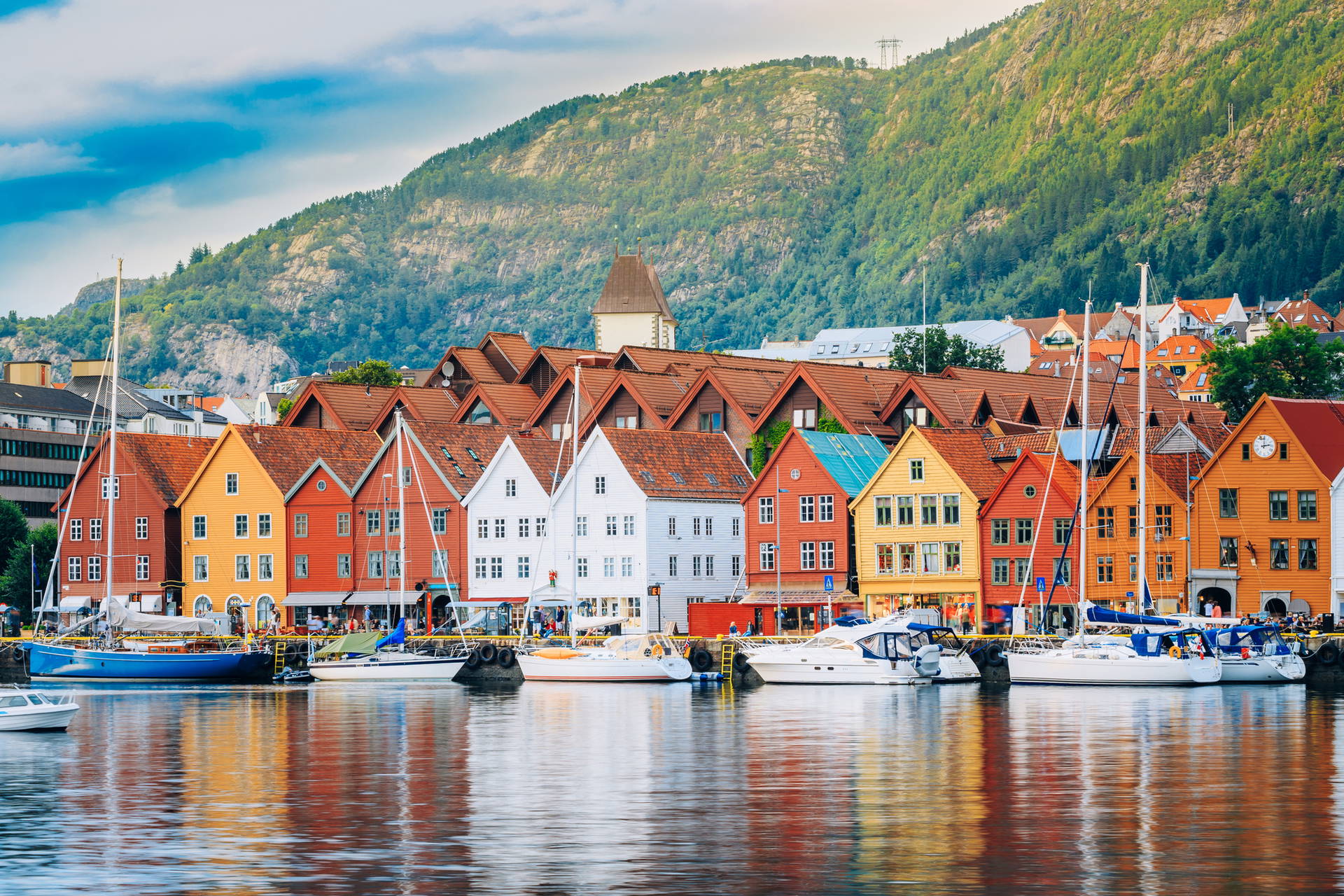 Bryggen w Bergen z kolorowymi budynkami i zacumowanymi łodziami.