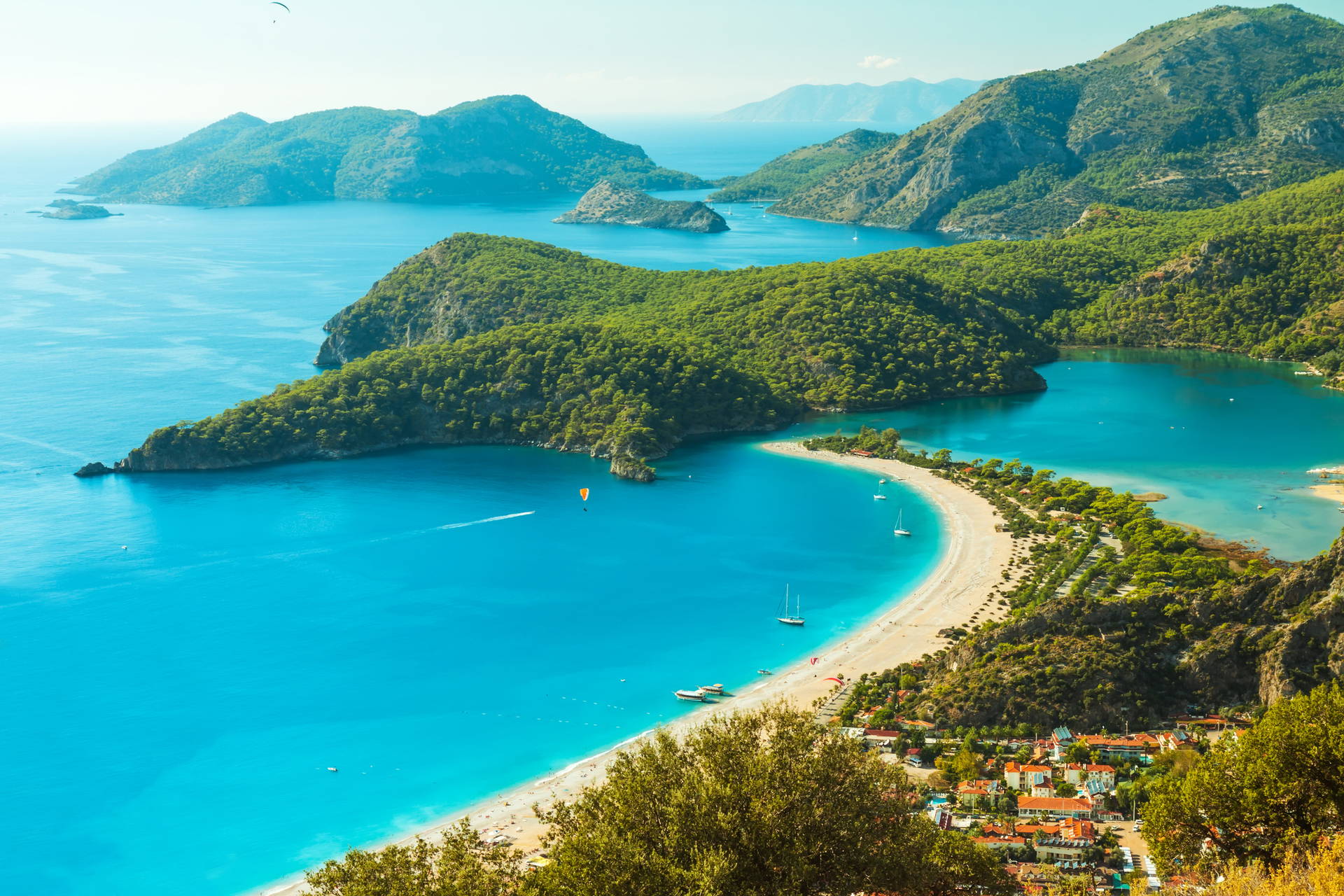 Oludeniz w Turcji z lotu ptaka: turkusowa woda, plaża i zielone wzgórza.