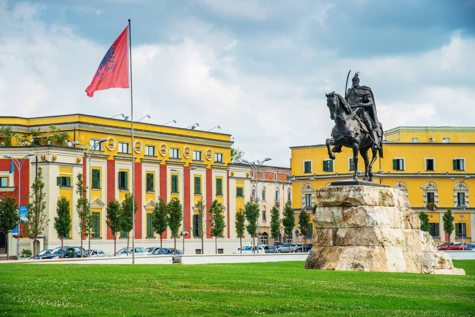 Plac Skanderbega w Tiranie ze statuą Skanderbega i albańską flagą.